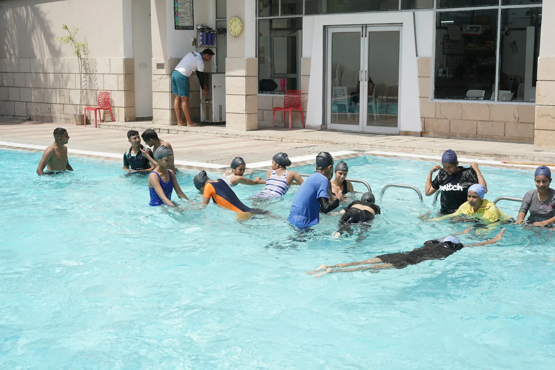 Sekelompok anak belajar berenang bersama instruktur