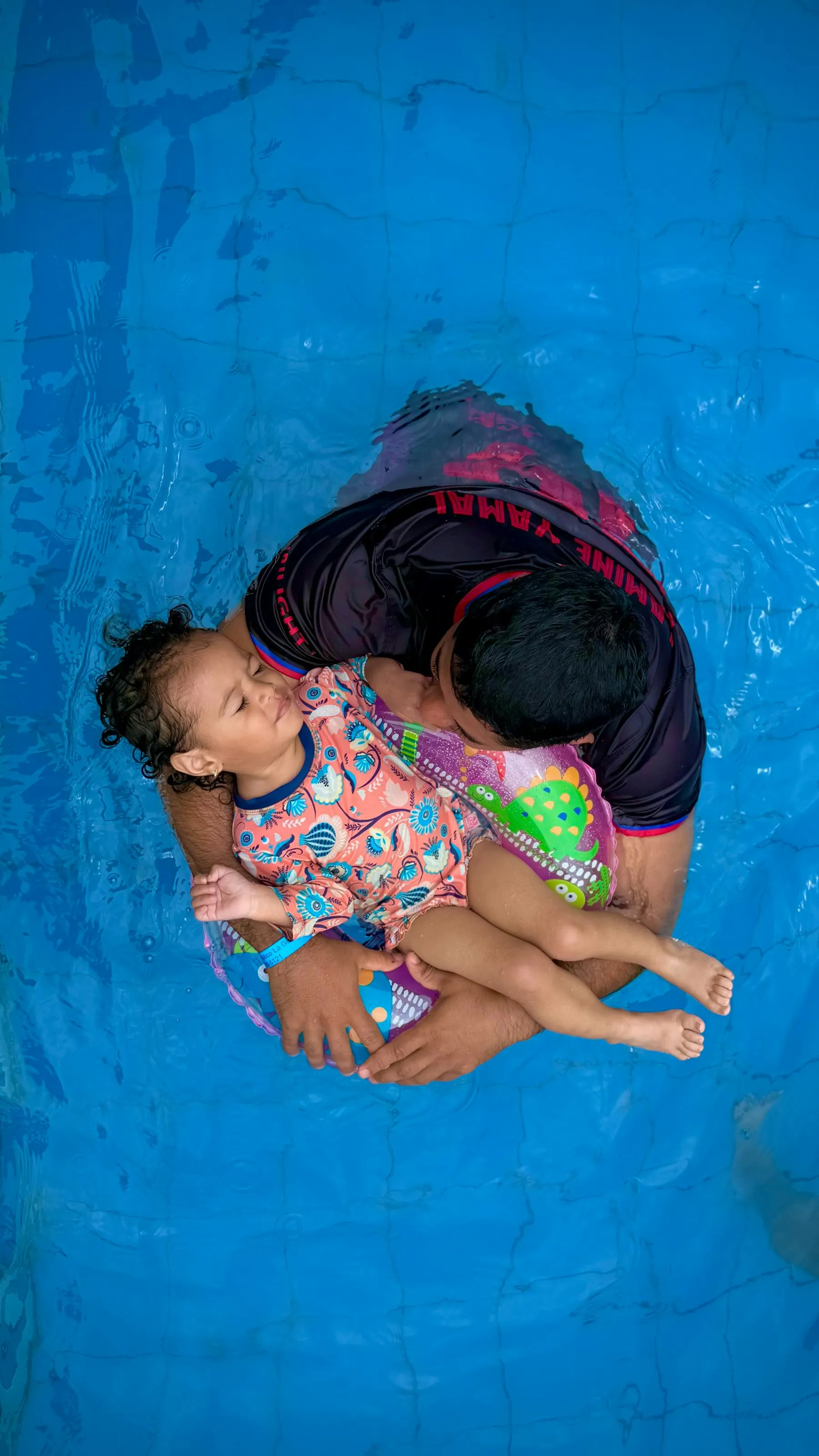 Instruktur mendampingi anak mengapung dengan tenang di air